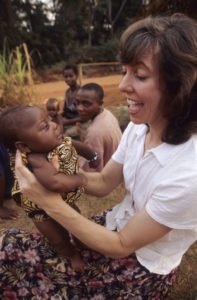 Christine Léonard plays with a Baka infant in a pygmy village in eastern Cameroon. (Photo by Dave Crough)